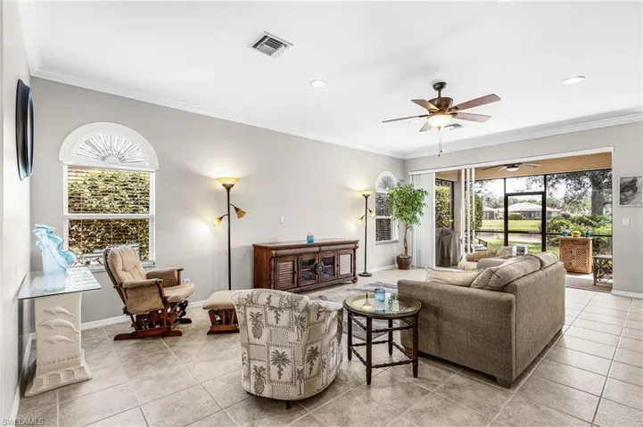 Living room with sliders to the screened in patio and open to the kitchen