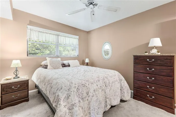 Bedroom with ceiling fan and light carpet