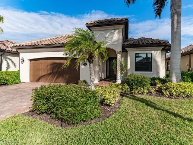 Mediterranean / spanish home featuring a front lawn and a garage