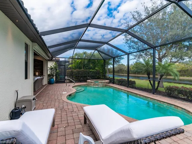 View of pool with a lanai, an in ground hot tub, and a patio area