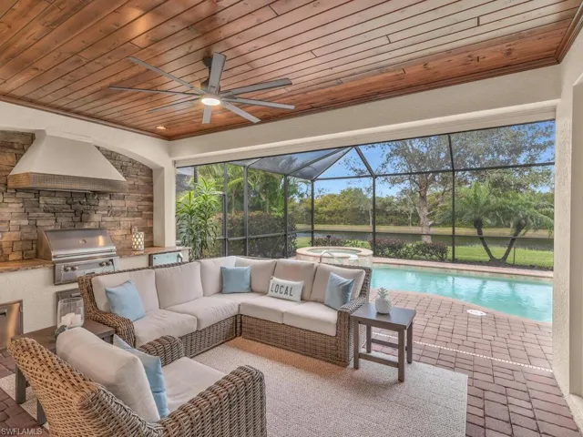 View of patio with a swimming pool with hot tub, a grill, an outdoor kitchen, glass enclosure, and outdoor lounge area