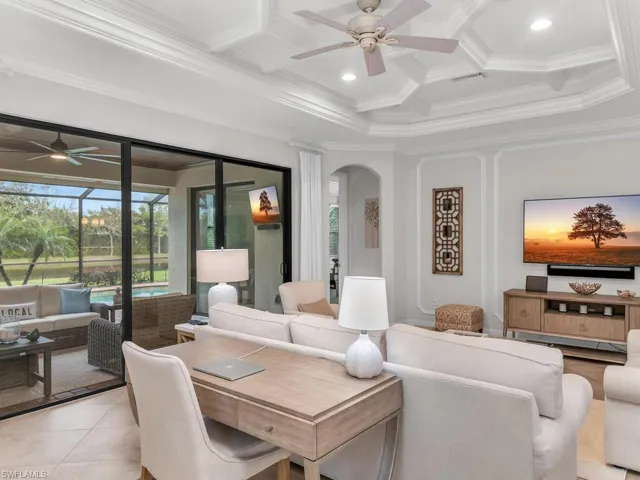 Living room featuring coffered ceiling, crown molding, beamed ceiling, ceiling fan, and light tile patterned flooring