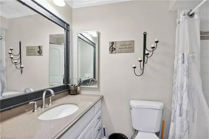 The spacious guest bathroom offers a classic tub and shower combination designed for ease and style.