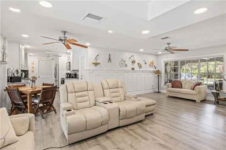 Natural light fills the living room, which opens directly to the kitchen and screened lanai, blending indoor comfort with outdoor beauty.