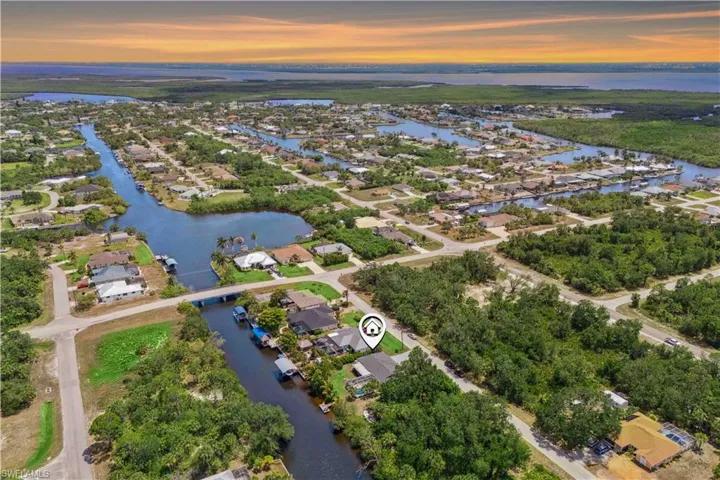 From above, watch the golden sunset paint the sky as it reflects off the tranquil waters of the community.