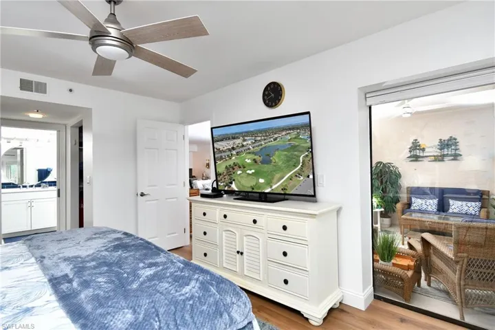 Primary bedroom opening into lanai with golf and water views