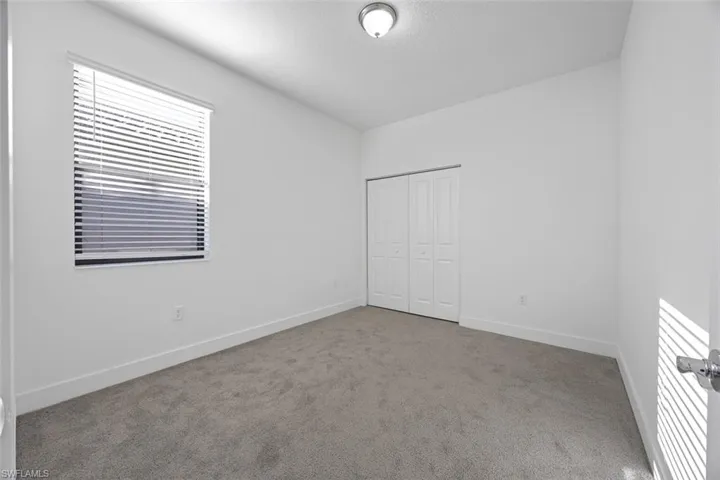 Unfurnished bedroom featuring carpet flooring, baseboards, and a closet