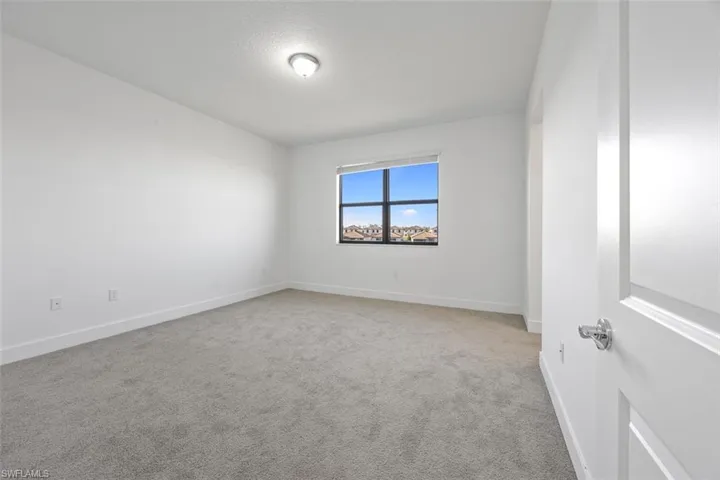 Carpeted spare room with baseboards