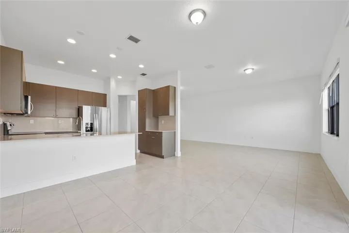 Kitchen with visible vents, open floor plan, stainless steel appliances, a peninsula, and light countertops