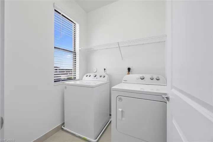 Washroom with laundry area, washing machine and dryer, and baseboards