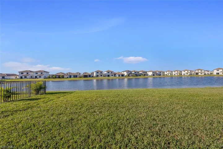 Property view of water with a residential view and fence