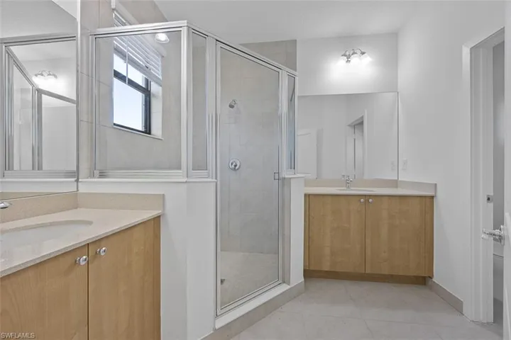 Full bathroom with a sink, two vanities, and a stall shower