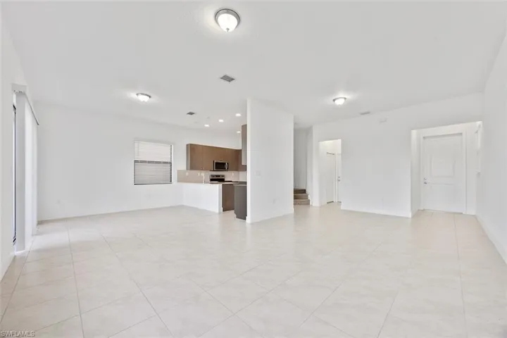 Unfurnished living room with visible vents and baseboards