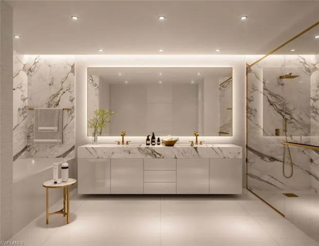 Full bath with a marble finish shower, double vanity, recessed lighting, and stone wall