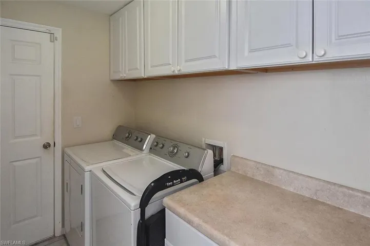 Laundry room leading to the 2-car garage has Maytag Centennial appliances, extra cabinets, and a folding area.