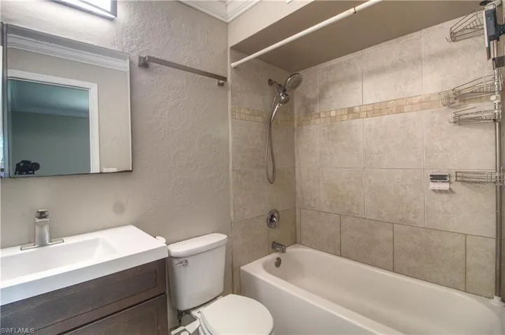 Master bathroom with vanity, ornamental molding, tiled shower / bath combo, and toilet