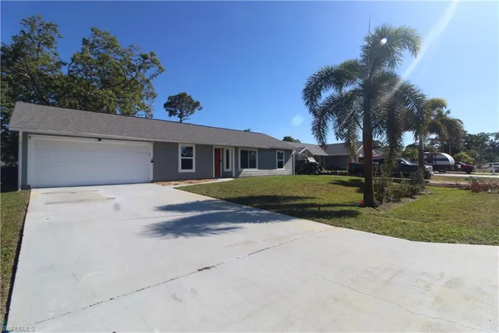 Ranch-style house featuring a garage and a front lawn