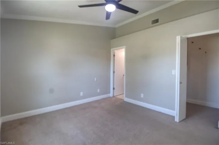 Master bedroom with carpet flooring, ceiling fan, and crown molding