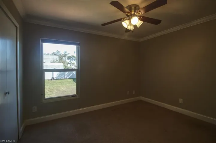 Guest room 1 featuring ceiling fan and crown molding