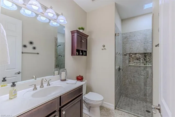 Full bathroom with a stall shower, vanity, and light tile patterned flooring