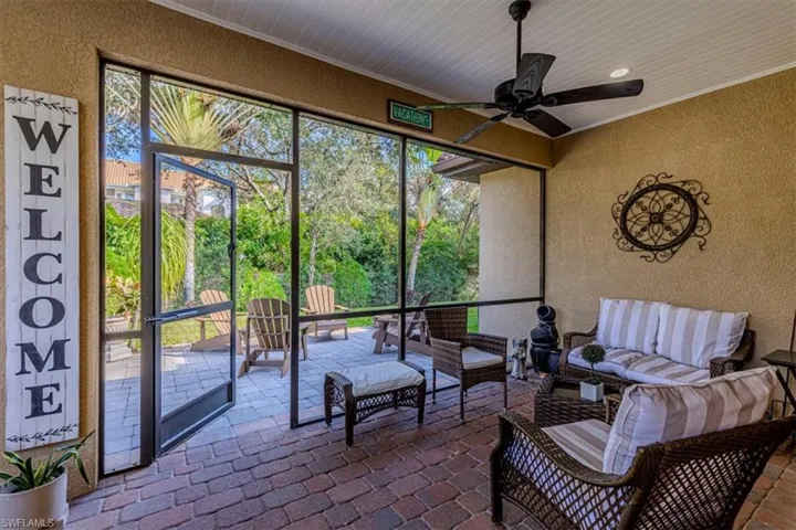 Sunroom / solarium with an outdoor hangout area, ceiling fan, and view of wooded area