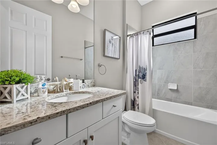 Bathroom featuring vanity, shower / tub combo, and light tile patterned floors