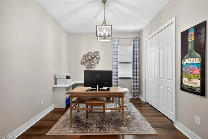 Office featuring dark wood-type flooring and a chandelier