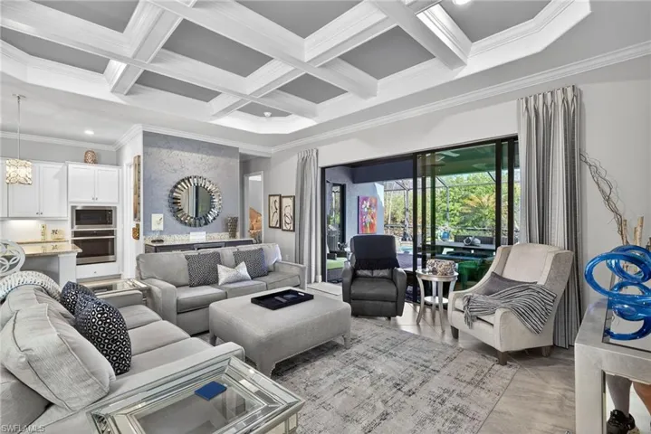 Living room featuring crown molding, coffered ceiling, and recessed lighting