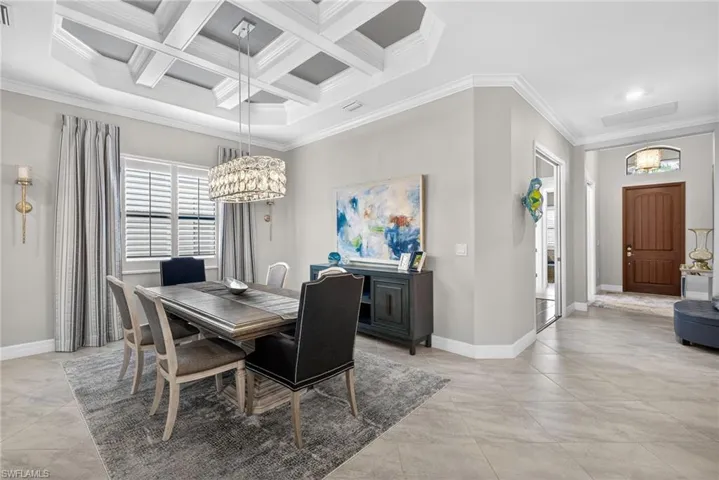 Dining space featuring crown molding, hanging lights, and coffered ceiling