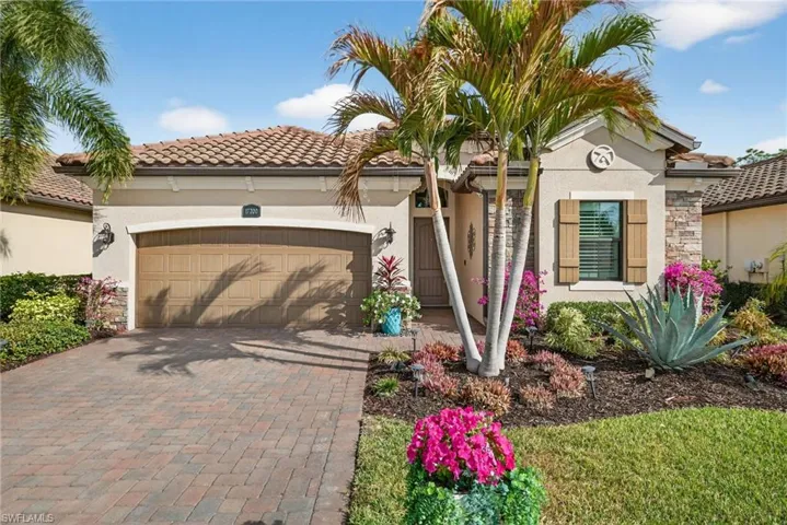 Mediterranean / spanish-style home featuring an attached garage, stucco siding, decorative driveway, and stone siding