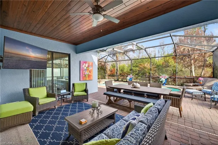View of patio featuring an outdoor lounge area, a sunroom, glass enclosure, ceiling fan, and an outdoor pool