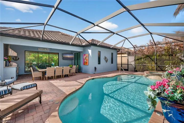 Integrated pool / spa with outdoor dining area, a patio, a sunroom, and a lanai