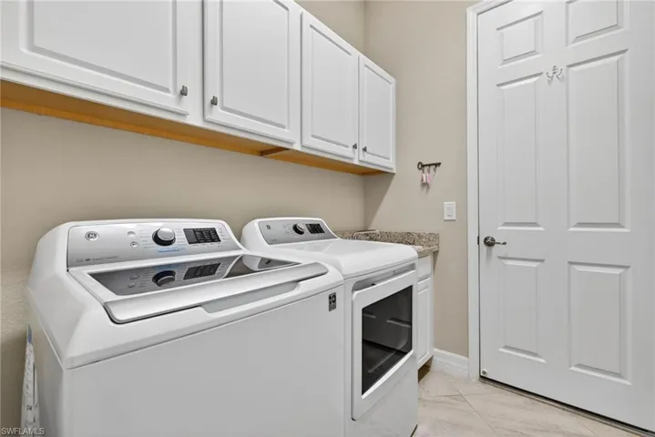 Laundry area with washer and clothes dryer and cabinet space
