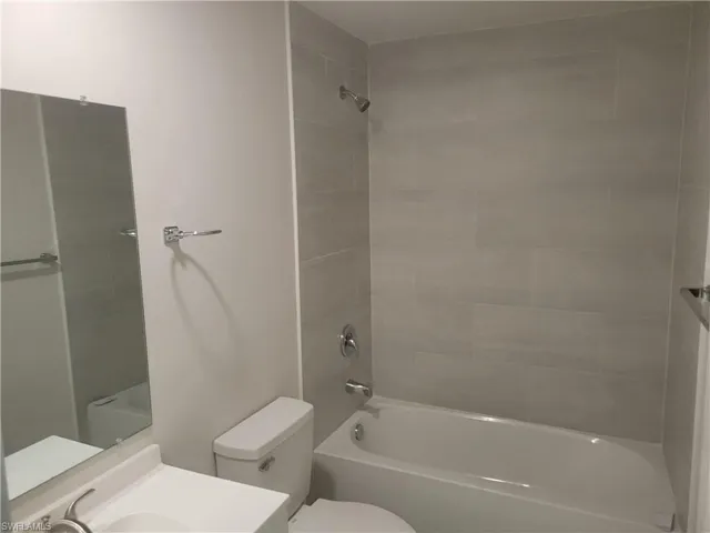 Full bathroom featuring vanity, toilet, and tiled shower / bath
