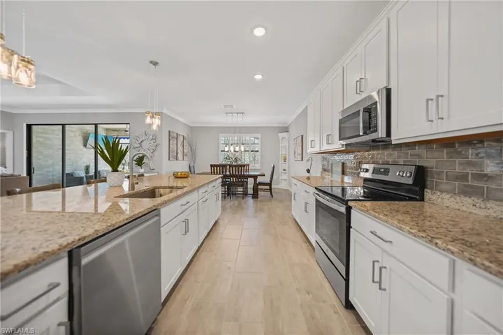 Beautifully appointed kitchen with neutral granite and custom backsplash