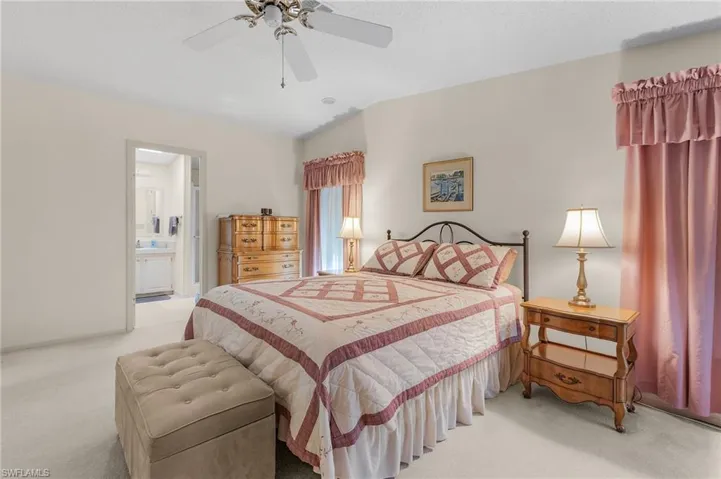 Bedroom with ceiling fan, carpet, ensuite bath, and baseboards