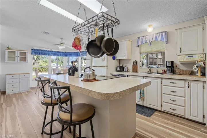 Kitchen featuring light wood-style floors, a breakfast bar, a center island, and light countertops