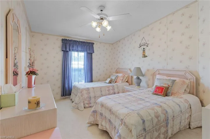 Bedroom featuring carpet floors, wallpapered walls, ceiling fan, and a textured ceiling