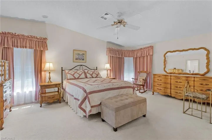 Carpeted bedroom with a textured ceiling, ceiling fan, and visible vents