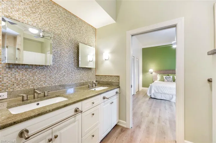 Guest bathroom features dual vanities and a walk-in shower.