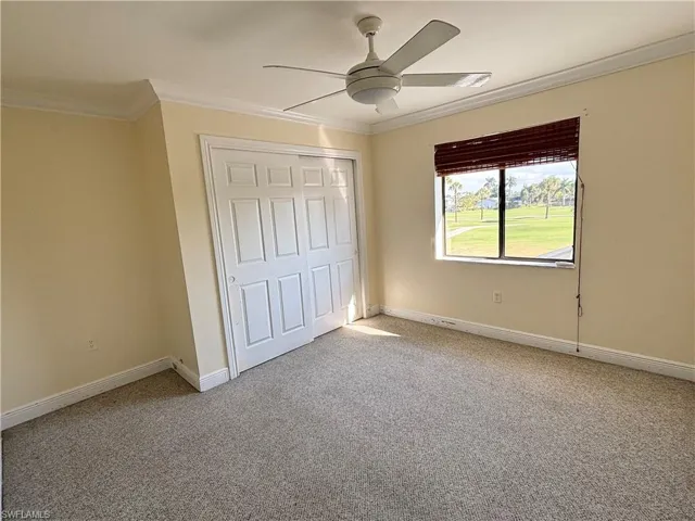 Unfurnished bedroom with crown molding, a closet, light colored carpet, and ceiling fan
