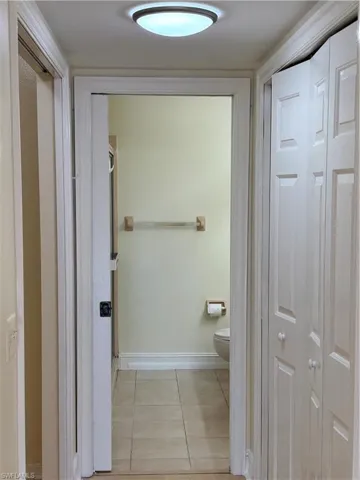 Bathroom with light tile patterned floors and a closet