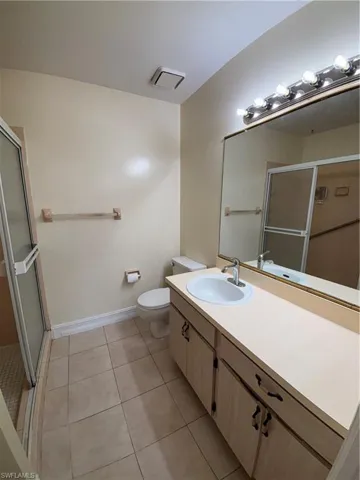 Full bath featuring a stall shower, vanity, and light tile patterned floors