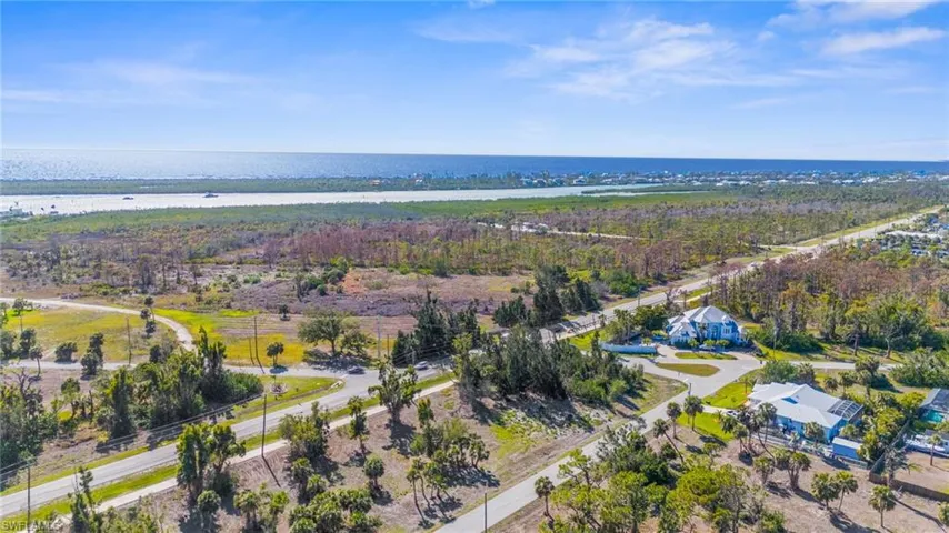 Aerial view of property and surrounding area with a nearby body of water