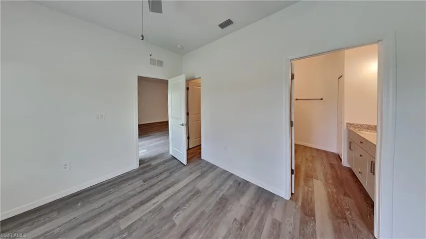 Unfurnished bedroom with light wood-type flooring and ensuite bathroom