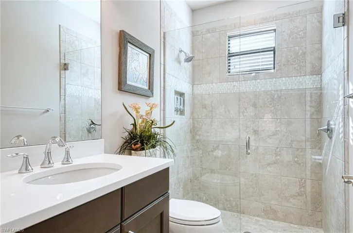 Bathroom featuring vanity, toilet, and a shower with shower door