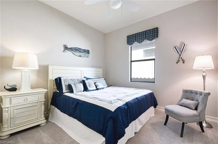 Bedroom with light carpet, ceiling fan, and lofted ceiling