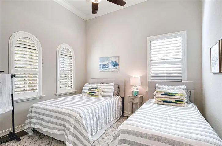 Bedroom featuring wood floor, crown molding, and ceiling fan
