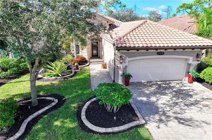 Mediterranean / spanish-style home featuring a garage and a front yard