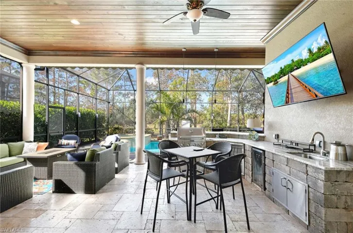 View of patio with a lanai, sink, exterior kitchen, and an outdoor hangout area